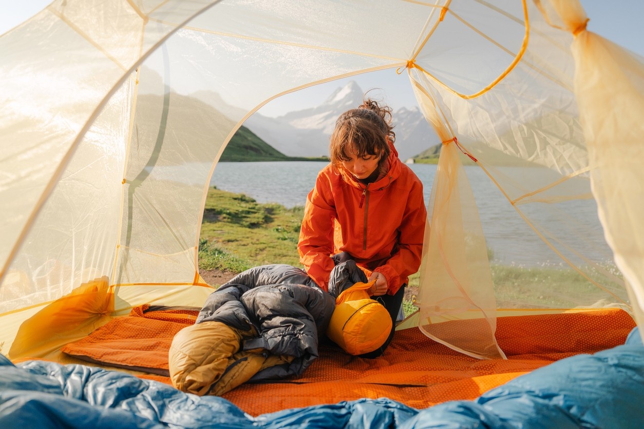 Camper packing her sleeping bag 