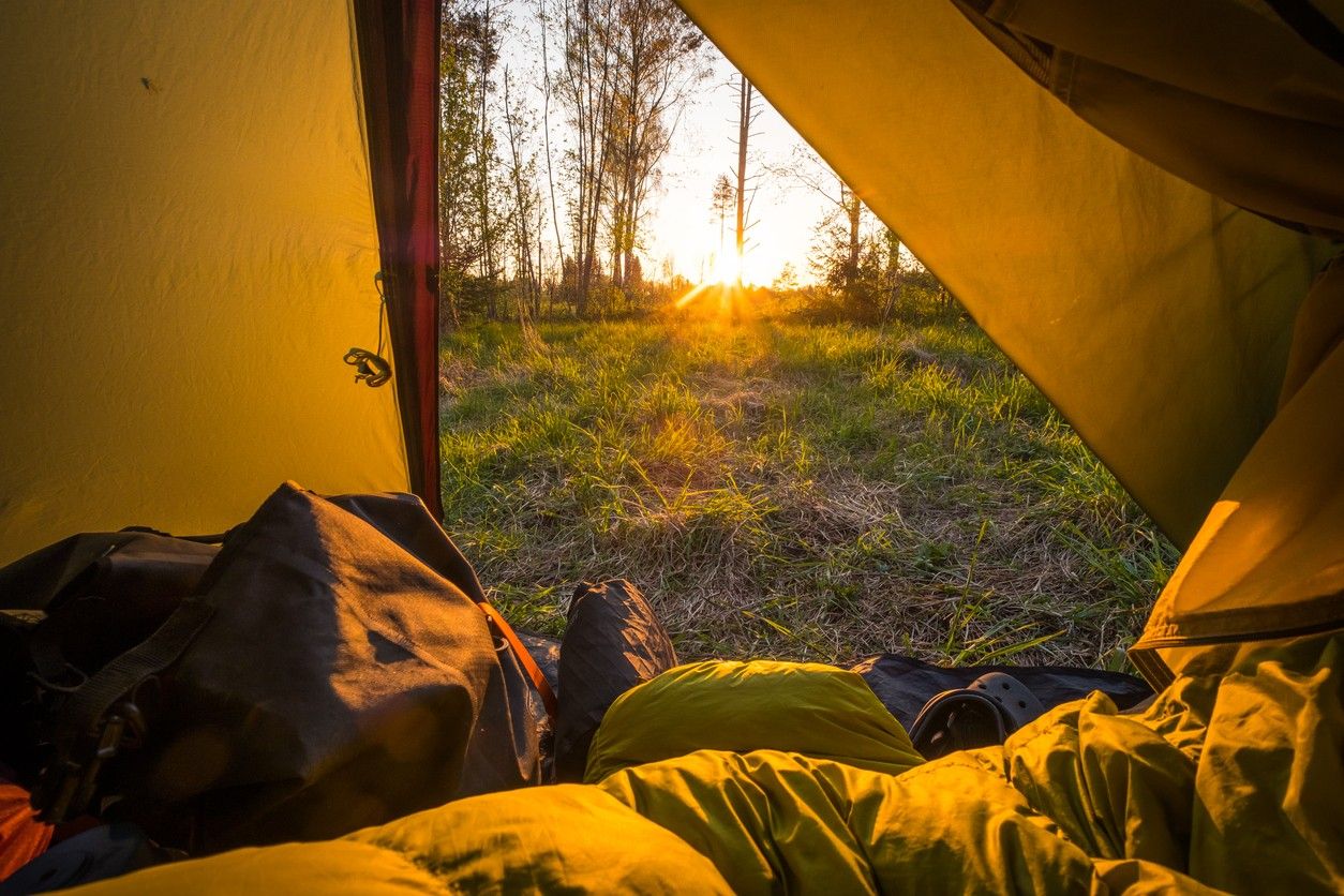 Camper relaxing on his sleeping bag in his tent