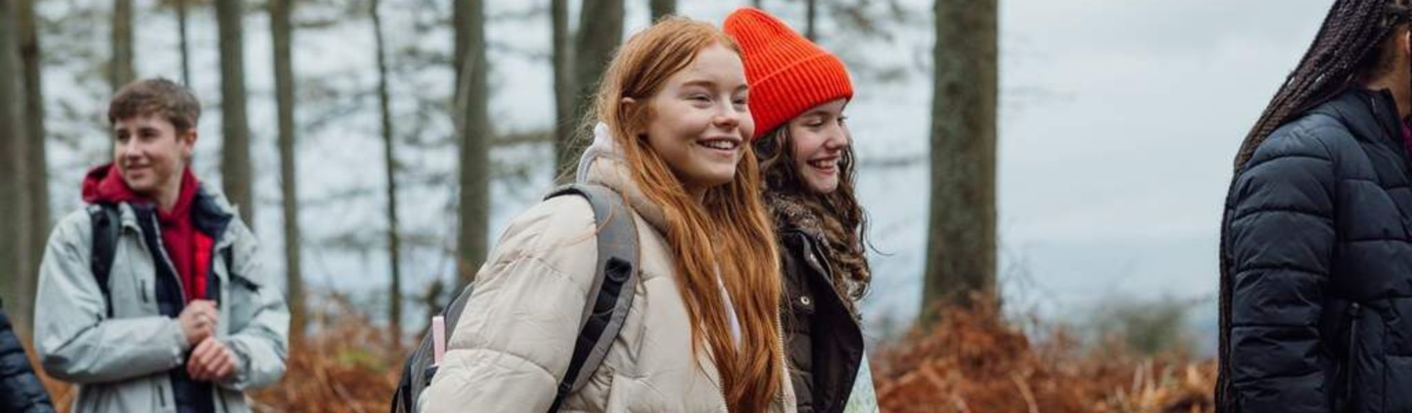 A shop assistant is helping to choose a jacket to a woman