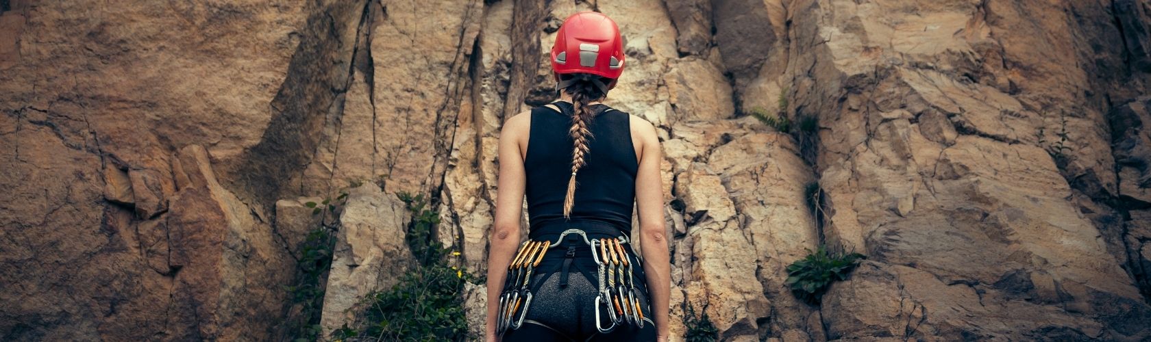 An image of a woman looking at a rock face she is about to climb 