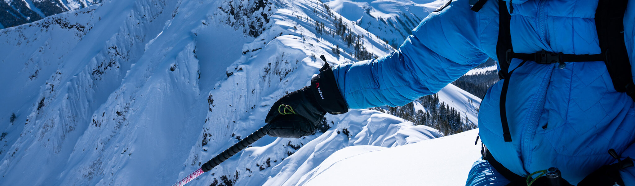 Someone wearing gloves at the top of a mountain