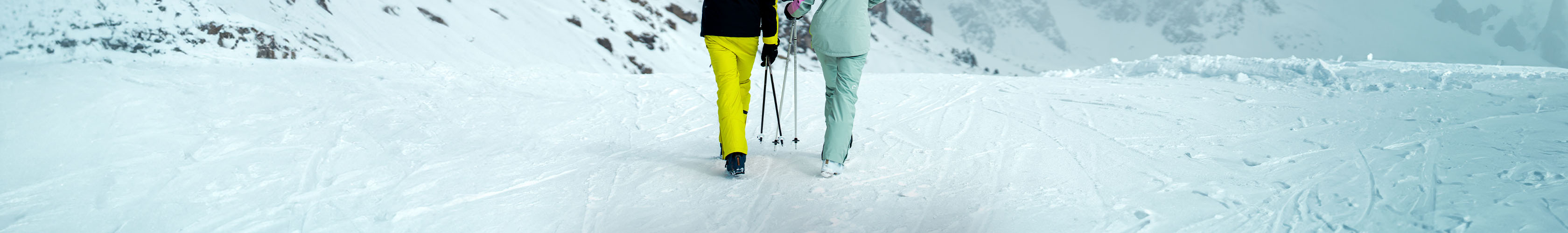 Two people wearing ski pants